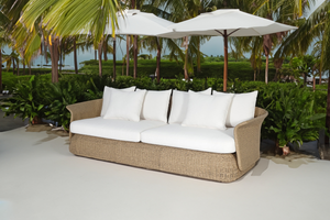 Catalina 3 Seater Outdoor Lounge in rattan cane natural colour with white cushions front view underneath sun umbrella in tropical setting